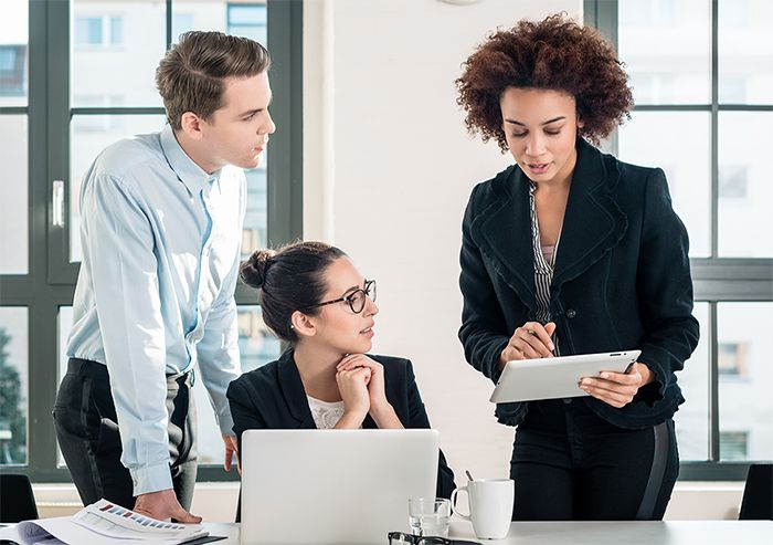 African american professional woman explaining rules as male and female caucasian professionals listen